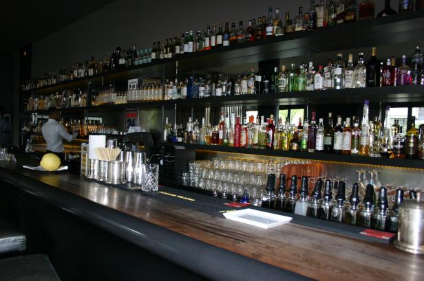 Eine Bar mit einer großen Auswahl an Spirituosen und einem Barkeeper im Hintergrund.