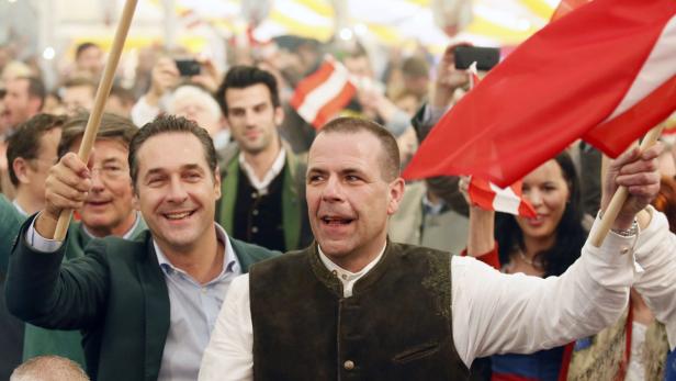 Menschen feiern mit rot-weiß-roten Fahnen in einer Menschenmenge.