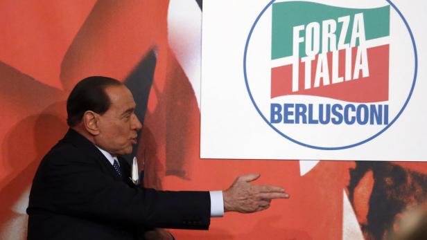 Silvio Berlusconi gestikuliert vor einem Logo von Forza Italia.