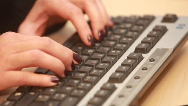 Eine Person tippt auf einer Computer-Tastatur.