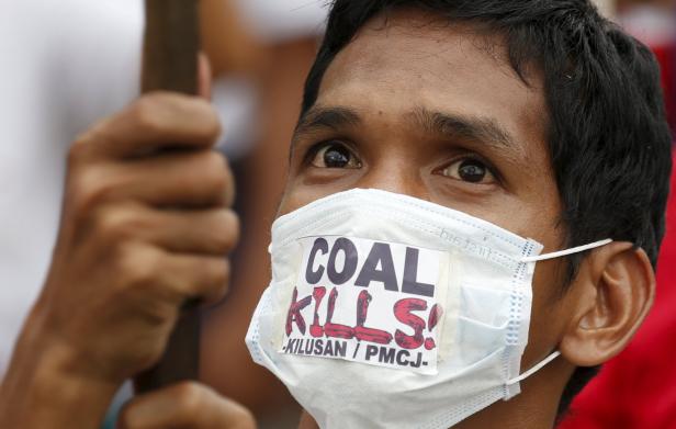 Ein Demonstrant trägt eine Maske mit der Aufschrift „Coal Kills!“.