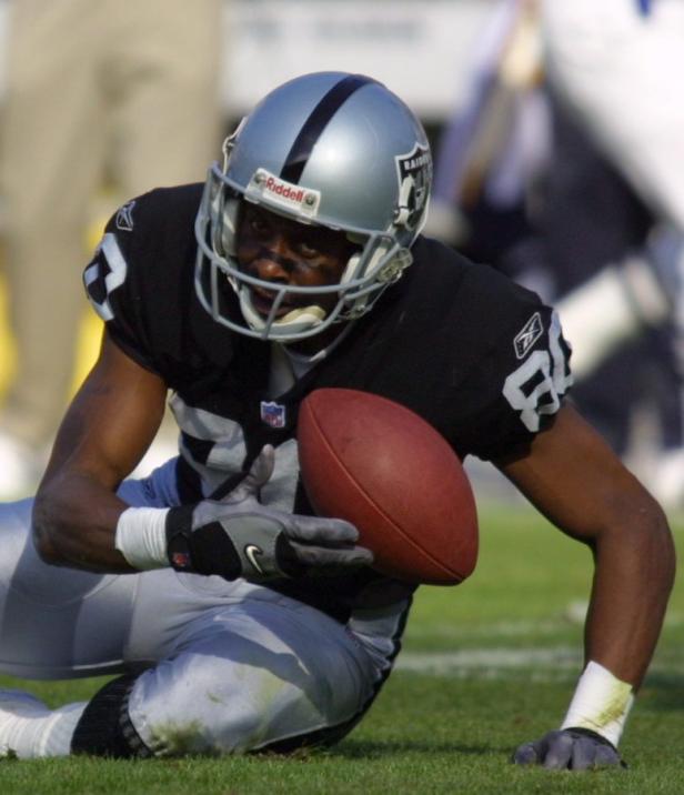 Ein Footballspieler der Raiders hält den Ball, während er auf dem Rasen kniet.