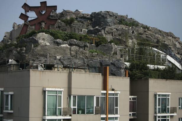 Ein Gebäude mit einem künstlichen Felsen und einer Skulptur auf dem Dach.