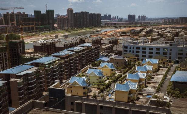 Luftaufnahme einer chinesischen Stadt mit Wohnhäusern und Hochhäusern.
