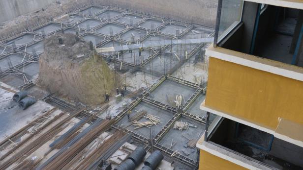 Bauarbeiter arbeiten an der Stahlbetonkonstruktion einer Baustelle.