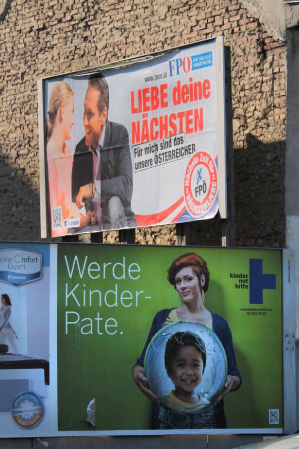 Zwei Wahlplakate: Eines von der FPÖ und eines für Kinderhilfe, an einer Hauswand angebracht.