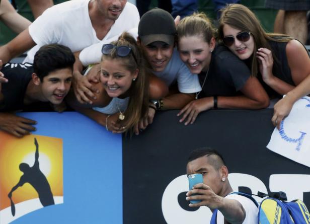 Nick Kyrgios macht ein Selfie mit Fans bei einem Tennismatch.