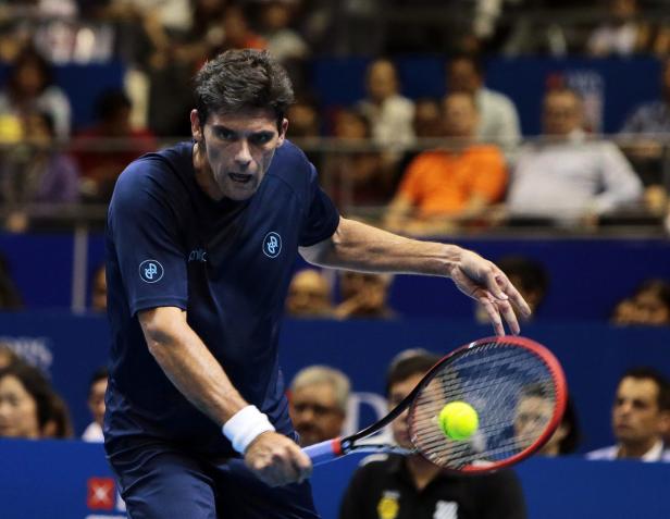 Ein Tennisspieler schlägt einen gelben Tennisball mit seinem Schläger.