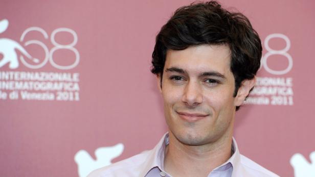 Porträt des Schauspielers Adam Brody vor dem Hintergrund der Filmfestspiele von Venedig.