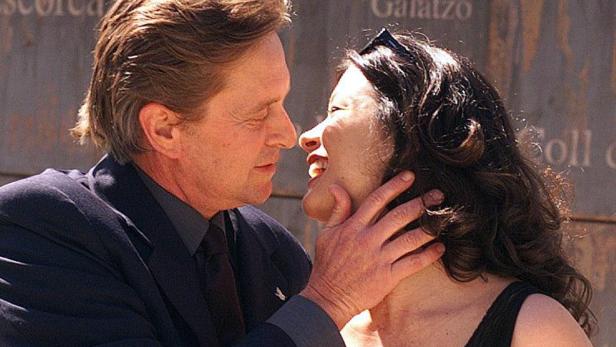 Michael Douglas berührt das Gesicht einer lächelnden Frau.