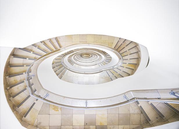 Eine spiralförmige Treppe windet sich nach oben, gesehen von unten.