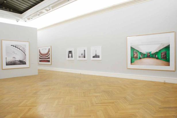 In einem Ausstellungsraum hängen mehrere gerahmte Bilder an den Wänden.