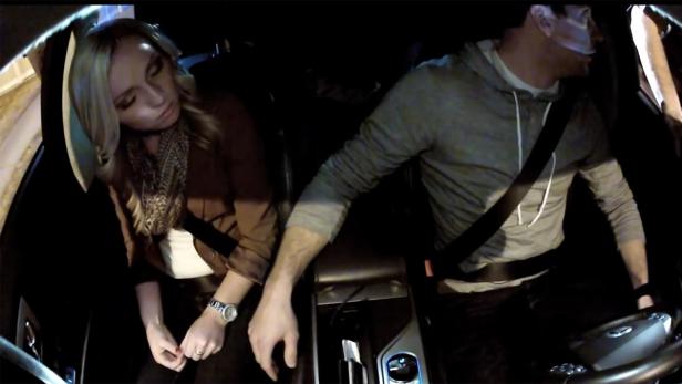 Eine Frau schläft im Auto, während ein Mann fährt.