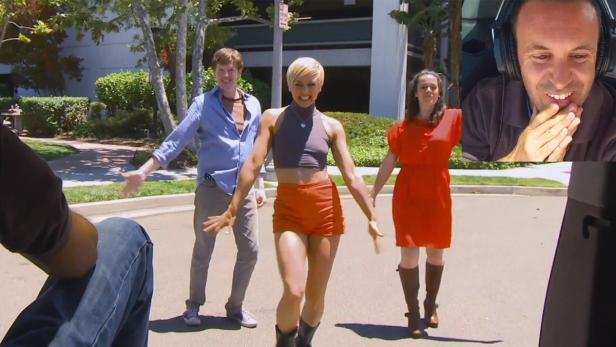 Drei Personen tanzen auf einer Straße, während eine vierte Person die Szene filmt und eine fünfte Person im Bild eingeblendet ist.