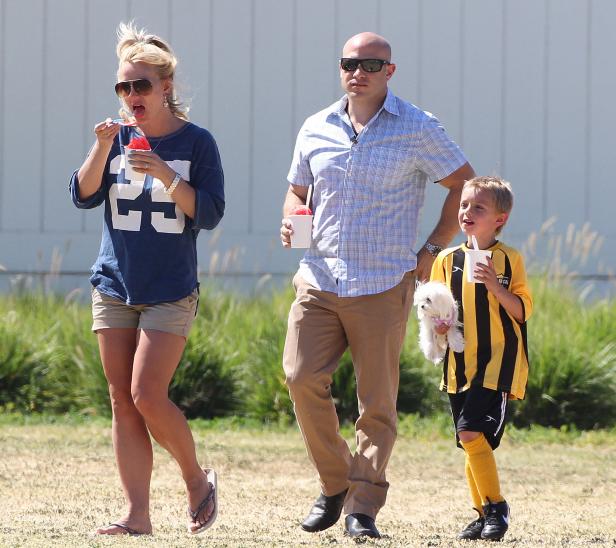 Britney Spears mit Familie und einem kleinen Hund auf einem Feld.