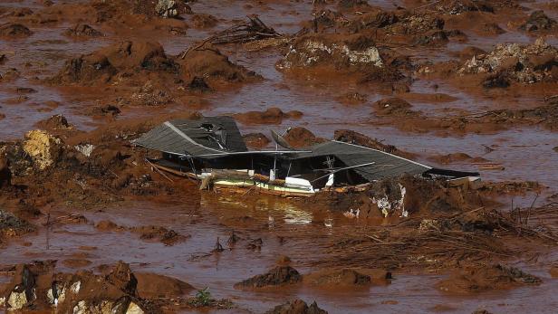 Ein zerstörtes Haus ist von einer braunen Schlammlawine umgeben.