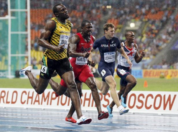 Usain Bolt und Justin Gatlin laufen bei einem Leichtathletik-Wettkampf im Regen.