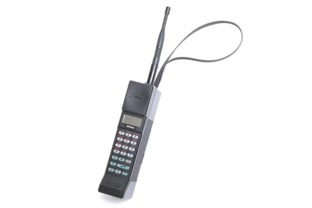 Ein älteres Nokia-Mobiltelefon mit Antenne und Trageschlaufe vor einem weißen Hintergrund.