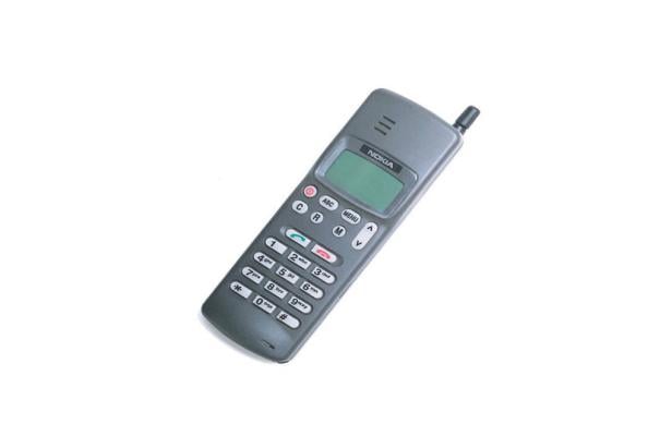 Ein graues Nokia-Handy mit Tastenfeld liegt auf einem weißen Hintergrund.