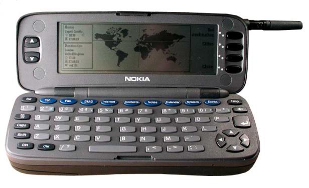 Ein geöffneter Nokia Communicator mit QWERTZ-Tastatur und Display, das eine Weltkarte zeigt.