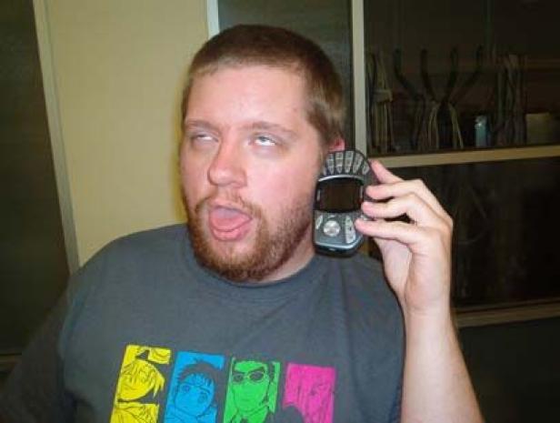 Ein Mann hält ein Mobiltelefon ans Ohr und verdreht die Augen.