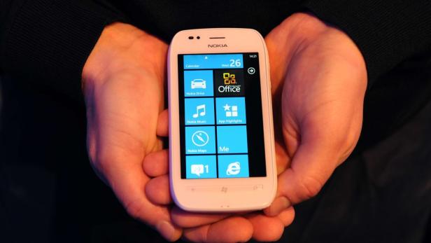 Ein weißes Nokia Smartphone mit Windows Phone wird in zwei Händen gehalten.