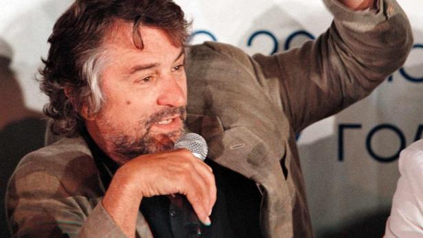 Robert De Niro spricht bei einer Veranstaltung in ein Mikrofon.