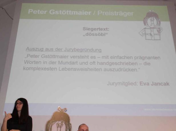 Präsentation mit Informationen zum Preisträger Peter Gstöttmaier und seinem Siegertext „dössöbi“.