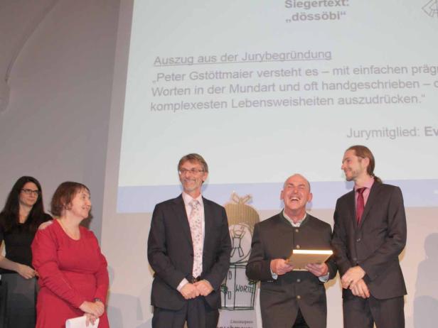 Eine Gruppe von Personen steht auf einer Bühne bei einer Preisverleihung.