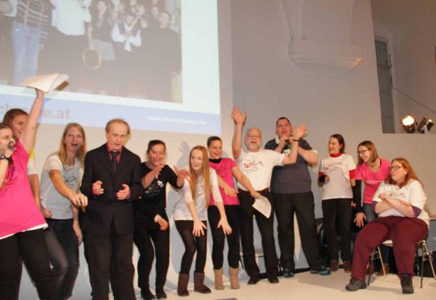 Eine Gruppe von Menschen steht auf einer Bühne und posiert für ein Foto.