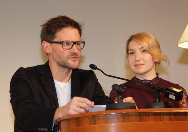 Ein Mann mit Brille und eine Frau stehen an einem Rednerpult.