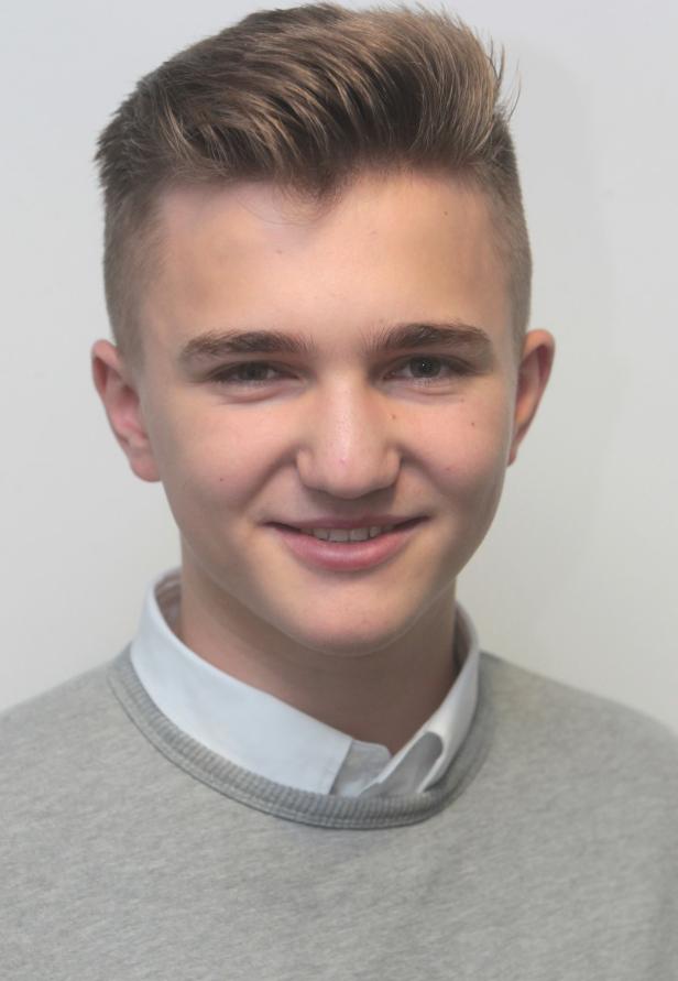 Ein junger Mann mit hellbraunen Haaren lächelt in die Kamera.