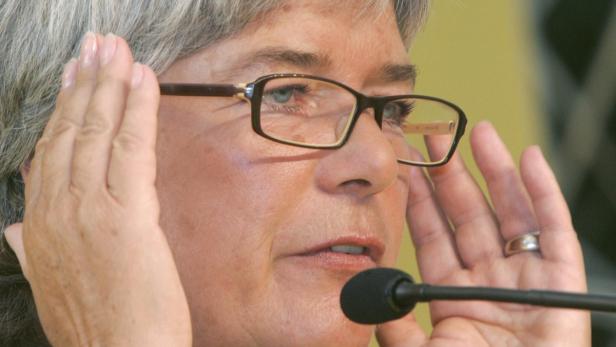 Eine Frau mit Brille spricht in ein Mikrofon.