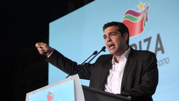 Alexis Tsipras hält eine Rede vor dem Hintergrund des SYRIZA-Logos.