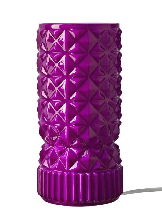 Eine lila Lampe mit einem geometrischen Muster steht auf einem weißen Hintergrund.