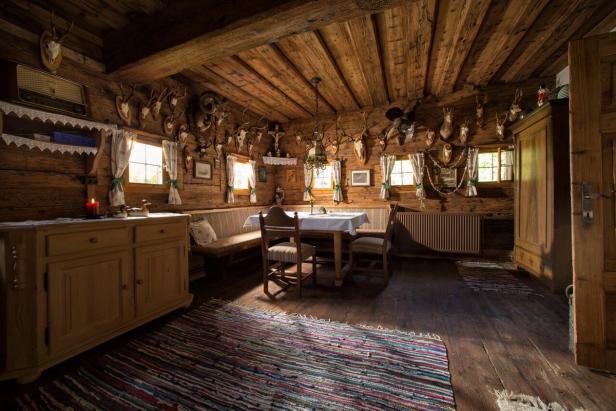 Ein rustikales Esszimmer in einem Holzhaus mit Jagdtrophäen an den Wänden.