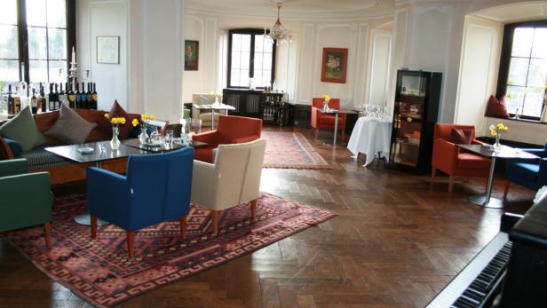 Ein elegantes Wohnzimmer mit verschiedenen Sitzgelegenheiten und einem Parkettboden.