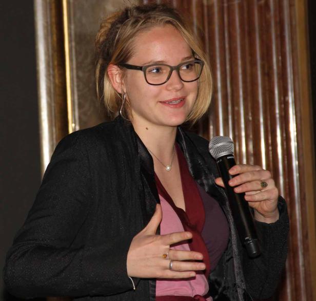 Eine Frau mit Brille spricht in ein Mikrofon.