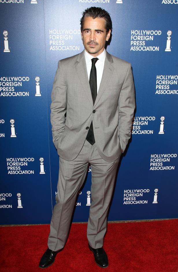 Colin Farrell posiert in einem grauen Anzug auf dem roten Teppich.
