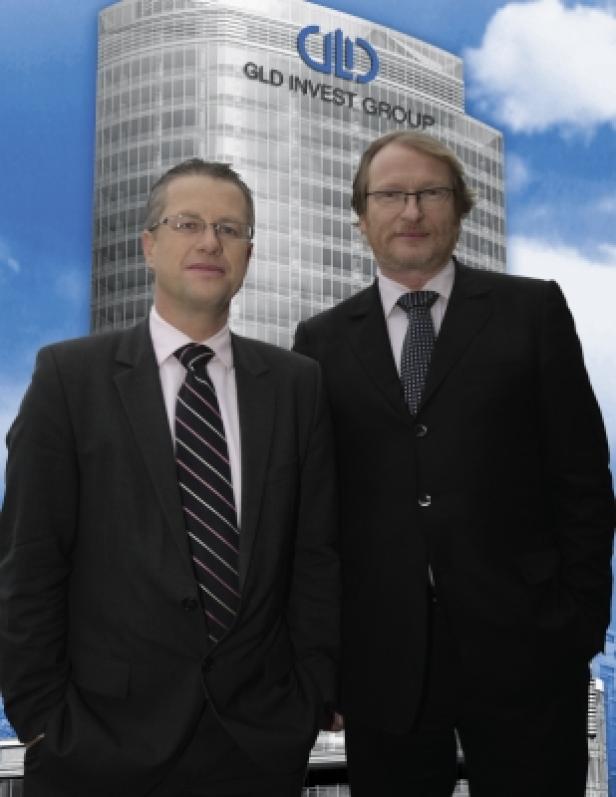 Zwei Männer in Anzügen stehen vor dem GLD Invest Group Gebäude.