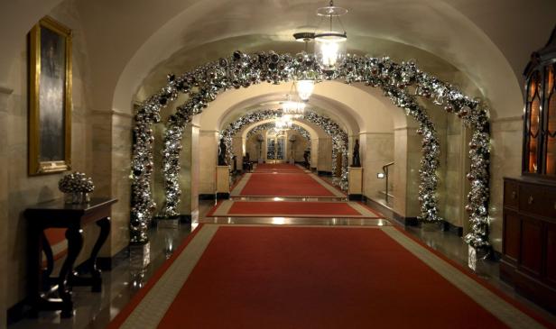 Ein langer Flur mit roten Teppichen und weihnachtlicher Dekoration.