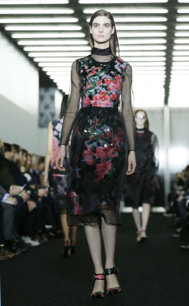 Eine Frau in einem floralen Kleid auf einem Laufsteg.