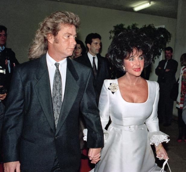 Larry Fortensky und Elizabeth Taylor gehen Hand in Hand.