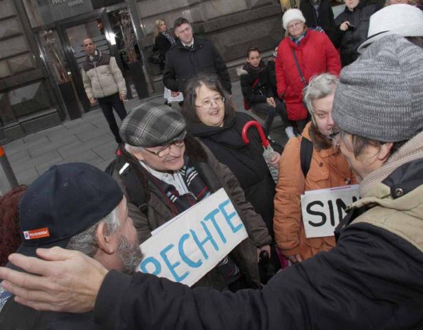 Eine Gruppe von Menschen demonstriert mit Schildern in der Hand.