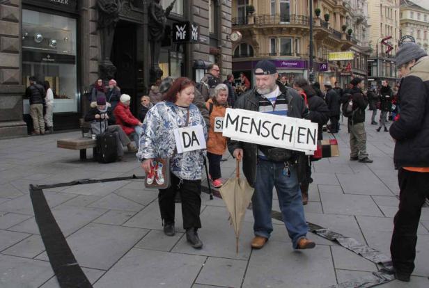 Zwei Personen demonstrieren mit Schildern, auf denen „Da sind Menschen“ steht.