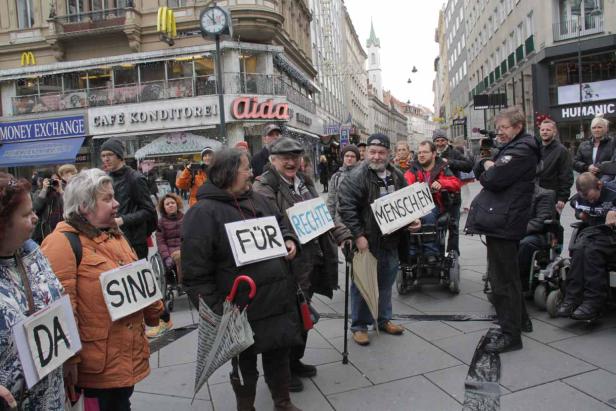 Eine Gruppe von Menschen demonstriert für ihre Rechte in einer belebten Stadt.