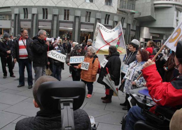 Eine Demonstration mit Menschen, die Schilder mit der Aufschrift „Menschenrechte sind für alle da“ halten.