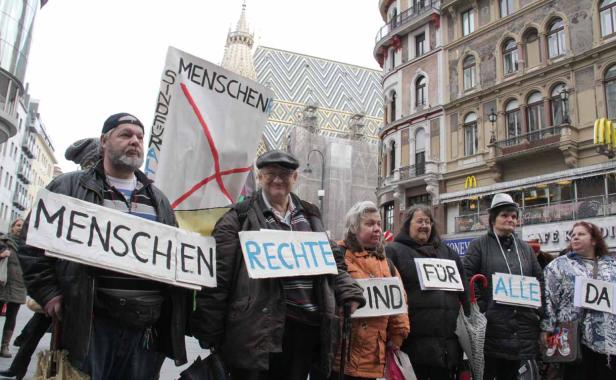 Eine Gruppe von Menschen demonstriert mit Schildern für Menschenrechte in einer Stadt.
