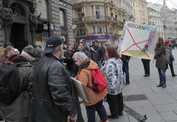 Eine Demonstration mit einem Plakat, das „Menschenrechte sind allerda“ zeigt.
