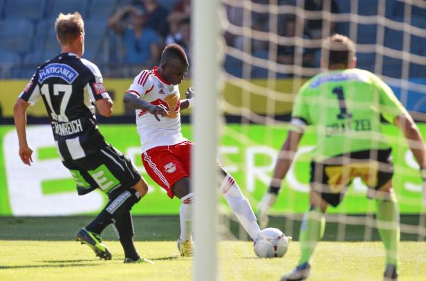 Ein Fußballspieler schießt den Ball in Richtung des Tors.